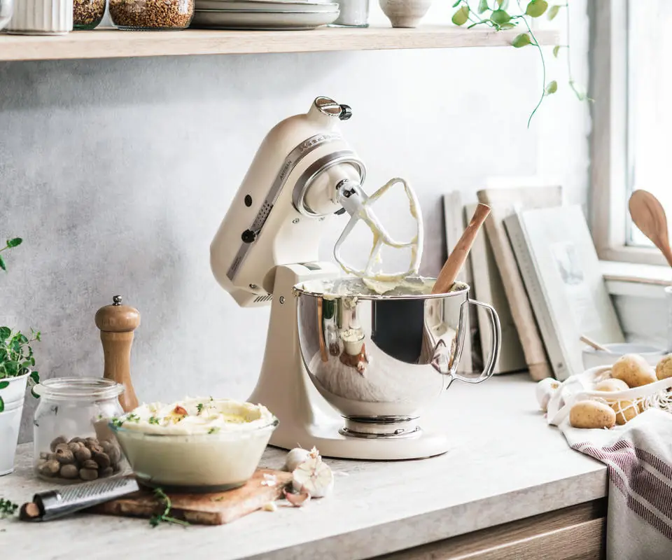 Robot planetarny KitchenAid Artisan w kolorze Fresh Linen na jasnym blacie kuchennym
